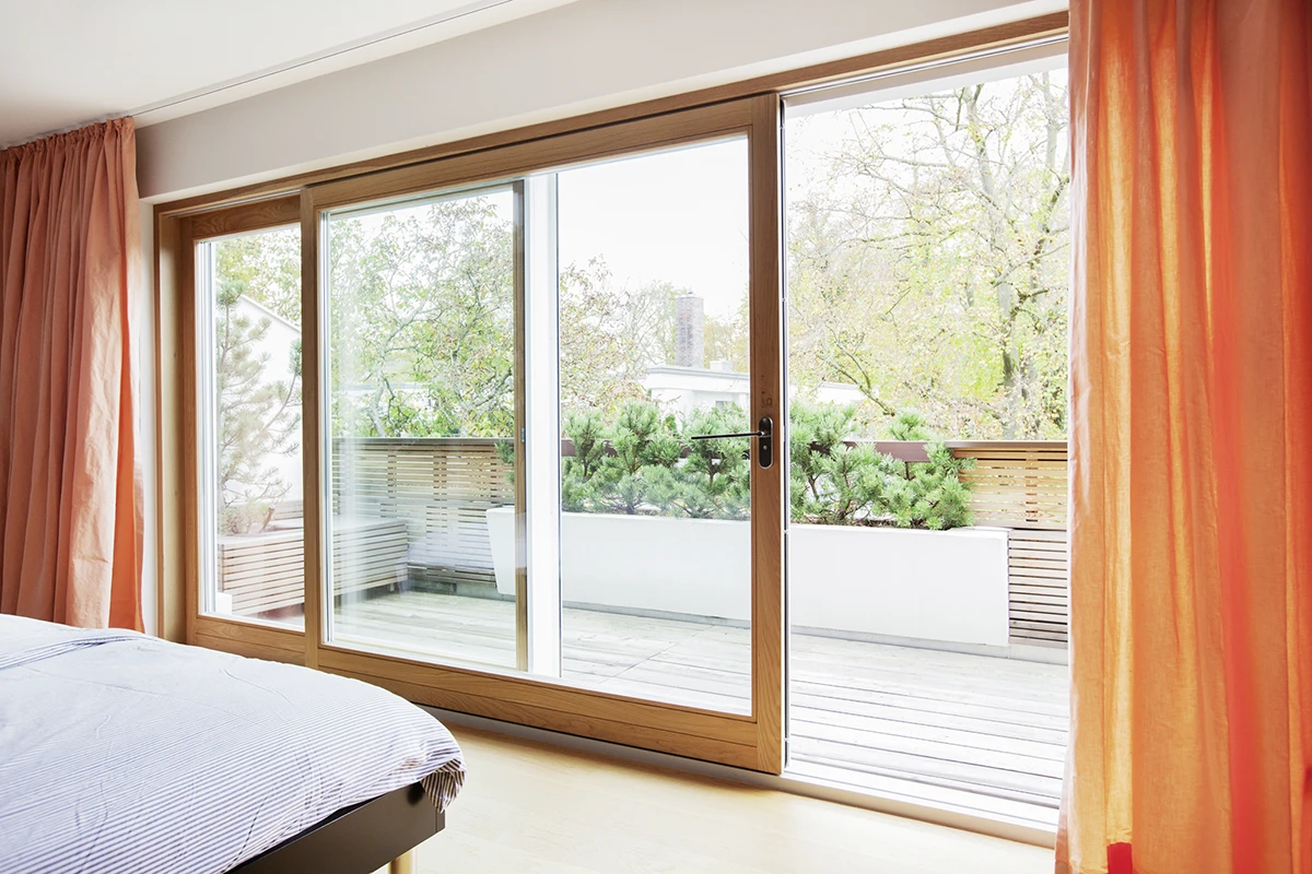 Blick durch die geöffnete Fensterfront auf den Balkon aus dem Schlafzimmer