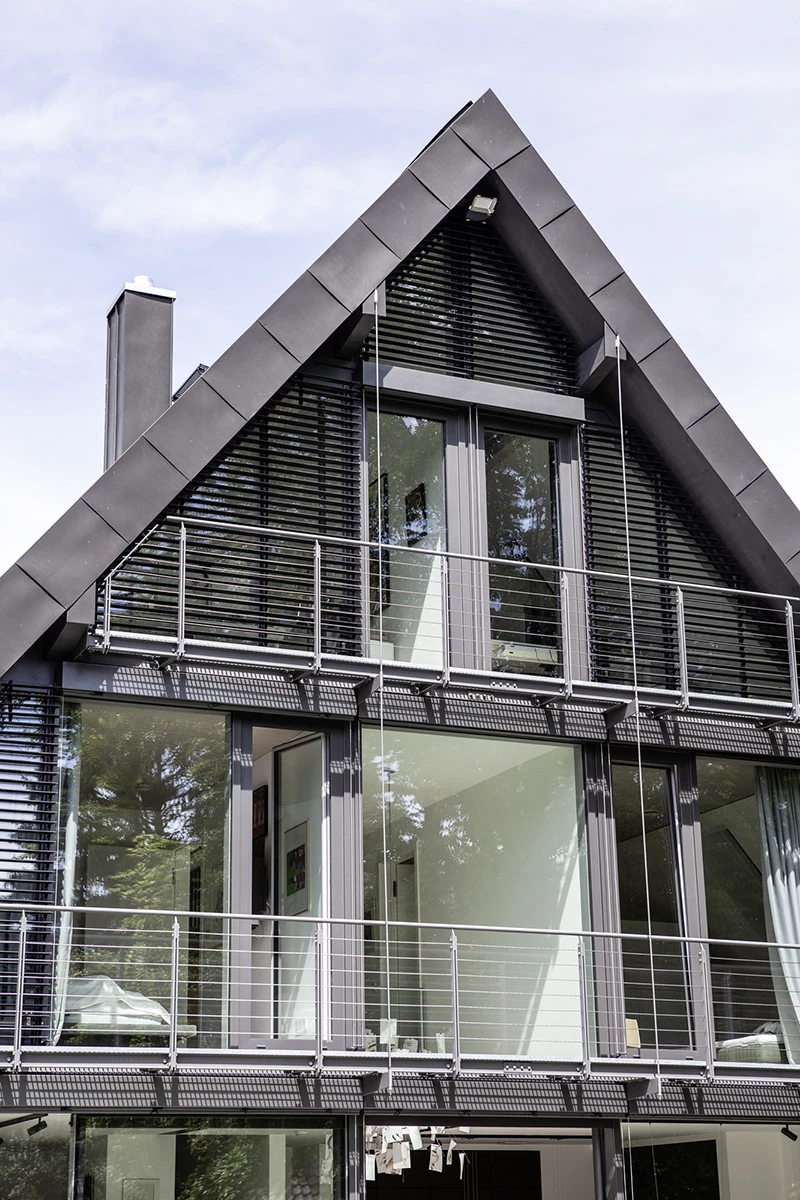 Blick auf das Haus vom Garten, komplette Fensterfront auf der Giebelseite, graues Dach