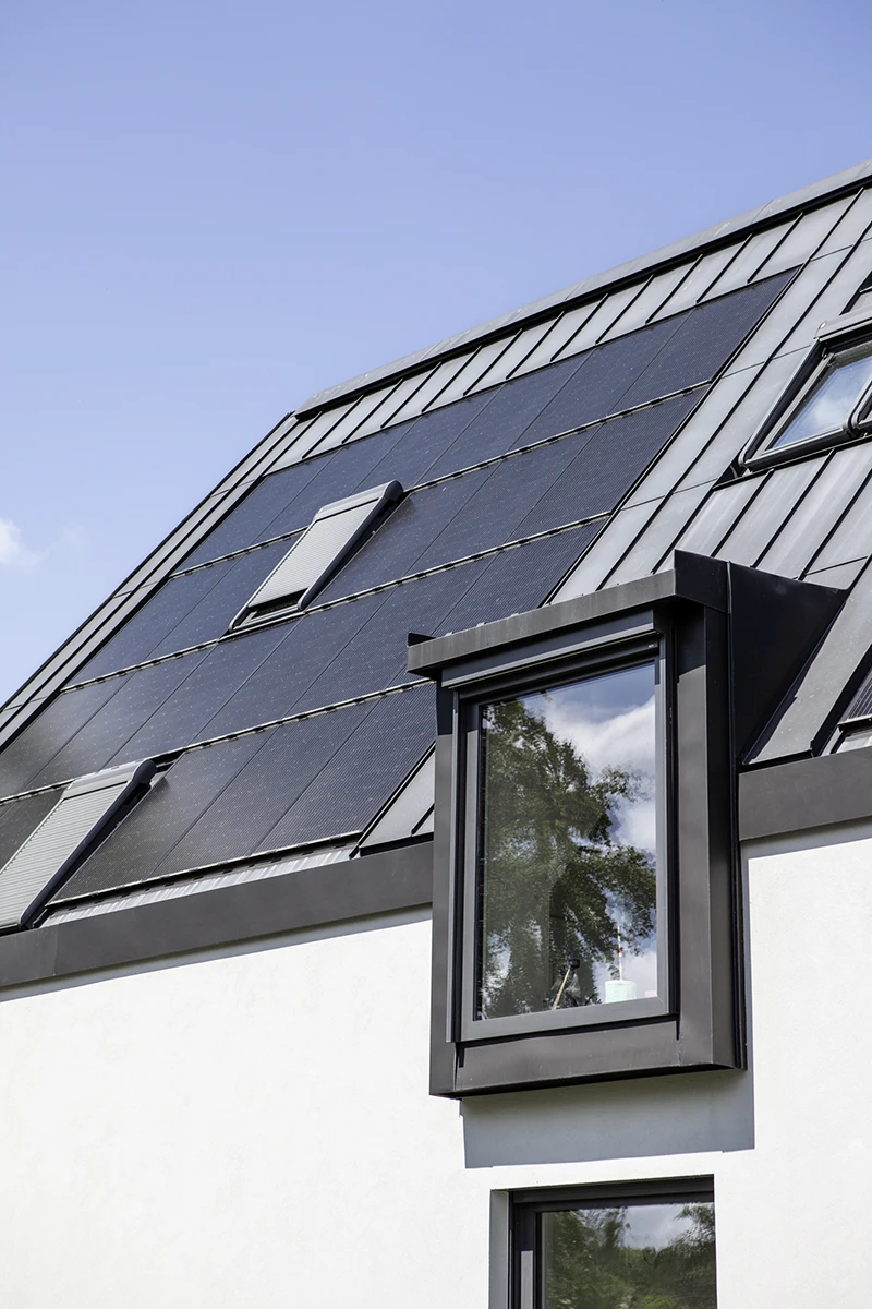 Dach des Hauses, grau, Dachfenster, dazwischen PV-Anlage