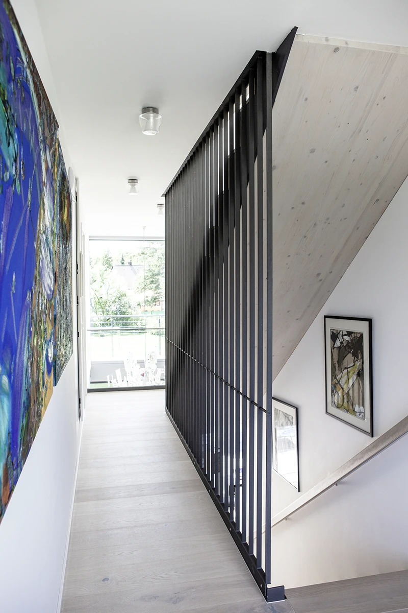 Flur, rechts Treppe nach unten, weisse Wände mit Gemälden, Holzboden