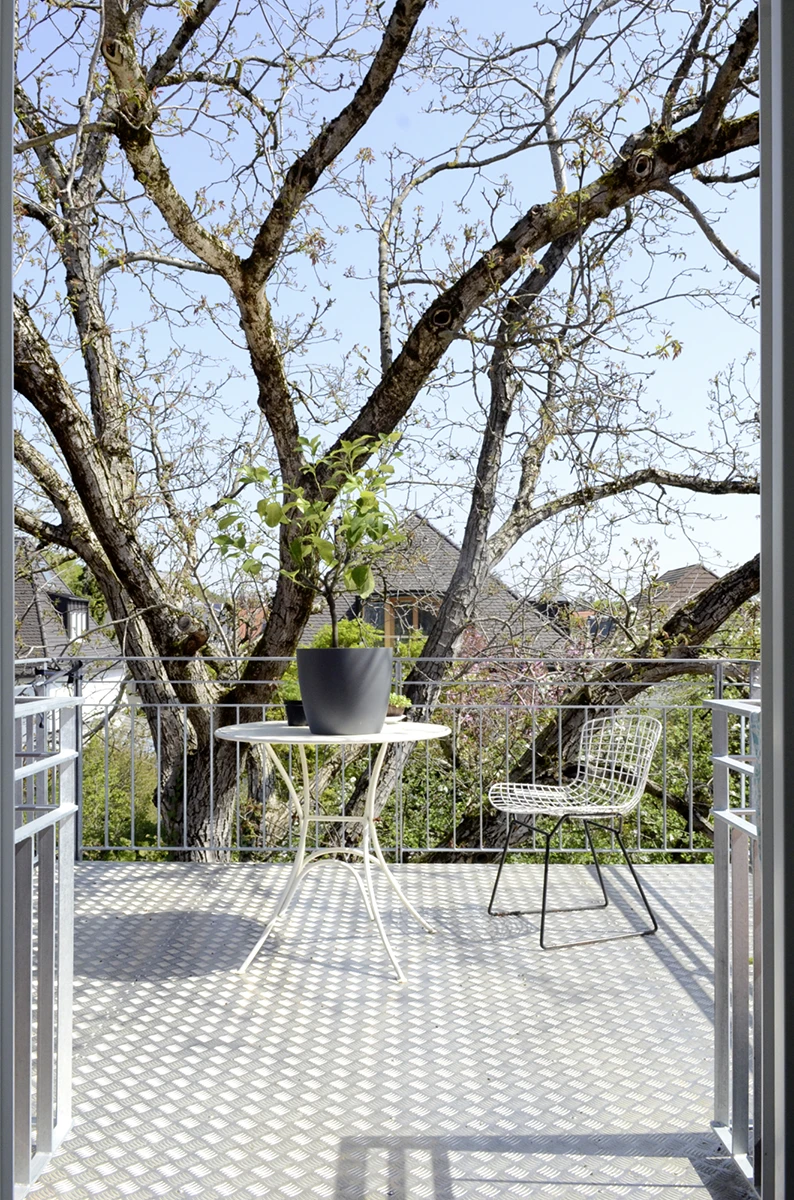 stoiber-architektur_sanierung_muenchen_vogelnest_05 Dachbalkon aus Metall mit Stühlen und Tisch
