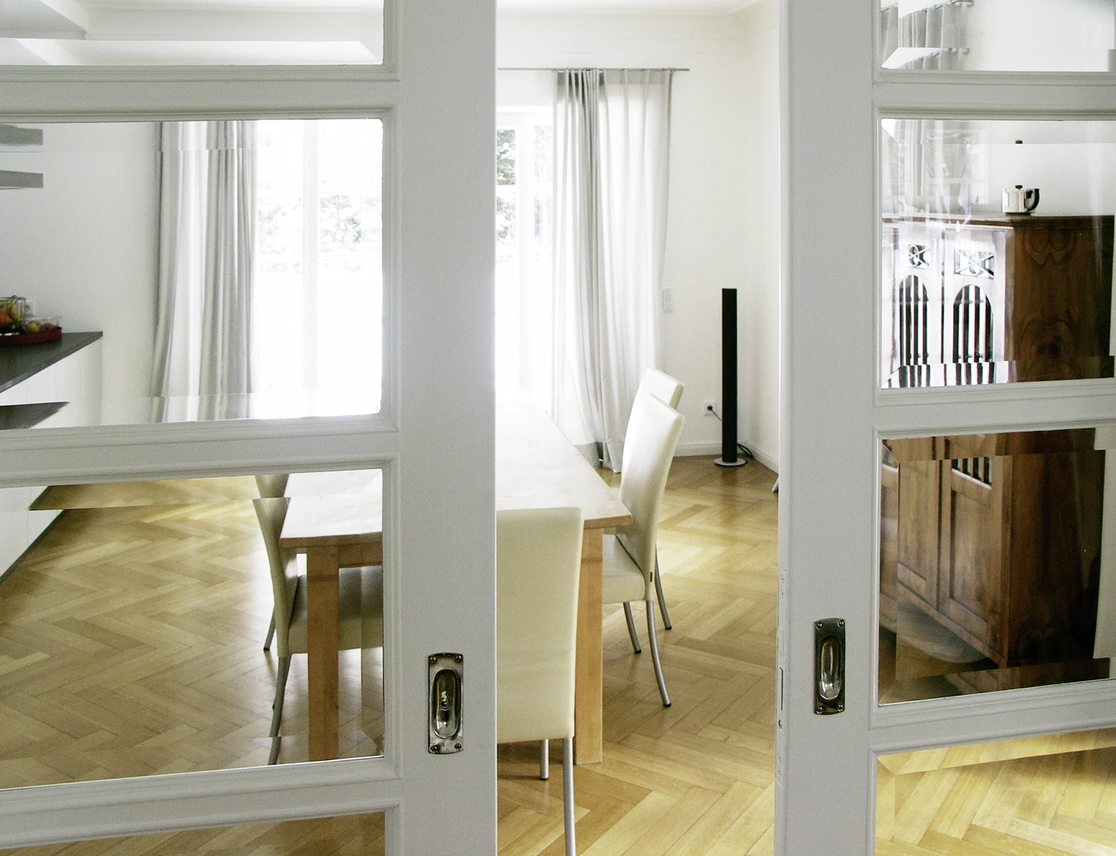 stoiber-architektur_sanierung_villa_harlaching_esszimmer_04 Blick durch die halbgeöffnete Tür auf den Koch- und Essbereich