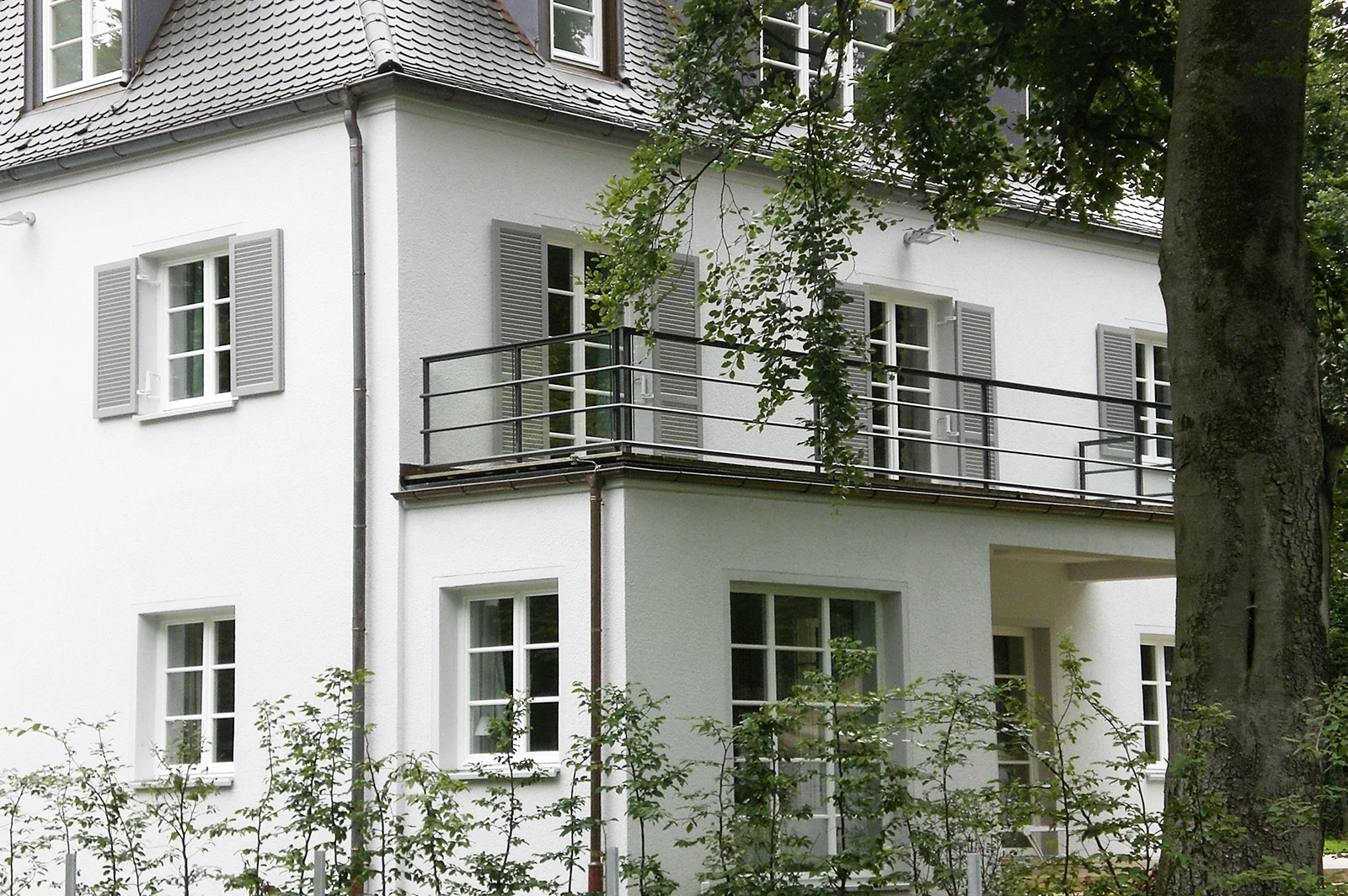 Seitlicher Blick von aussen auf dass das sanierte Haus im Sommer