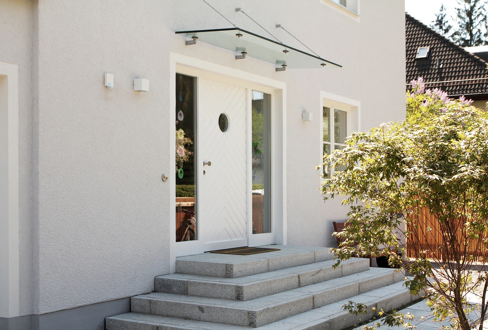 stoiber-architektur_sanierung_villa_sendling_eingangsbereich-aussen_03 Eingangsbereich des Gebäudes mit Glasvordach und mehreren Stufen bis zur Tür