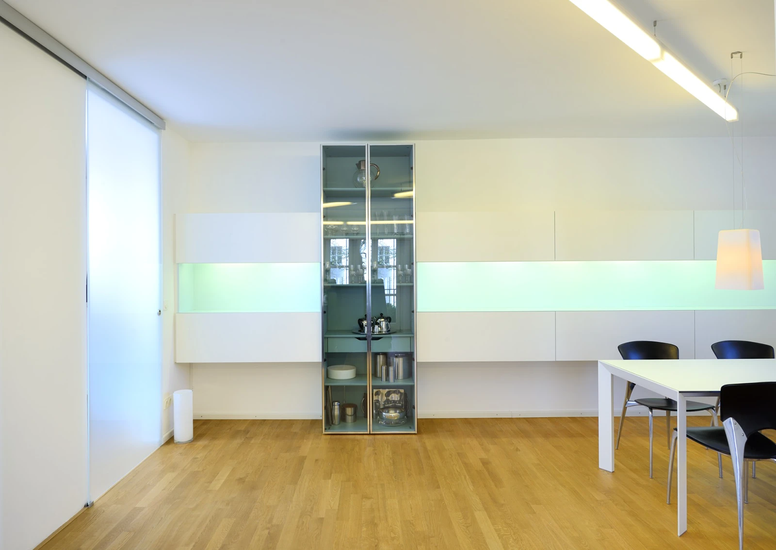 Essbereich der Wohnung mit Lichtinstallation in der Wand, Vitrinenschrank