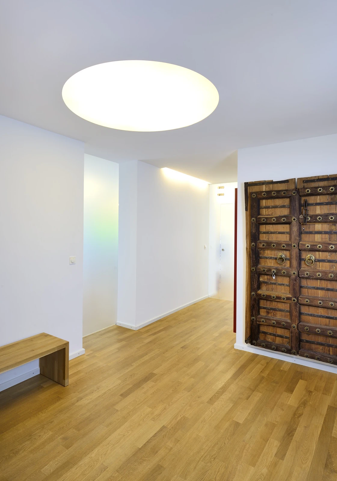 Eingangsbereich der Wohnung mit Holzfussboden, Milchglastüren und großer Deckenleuchte